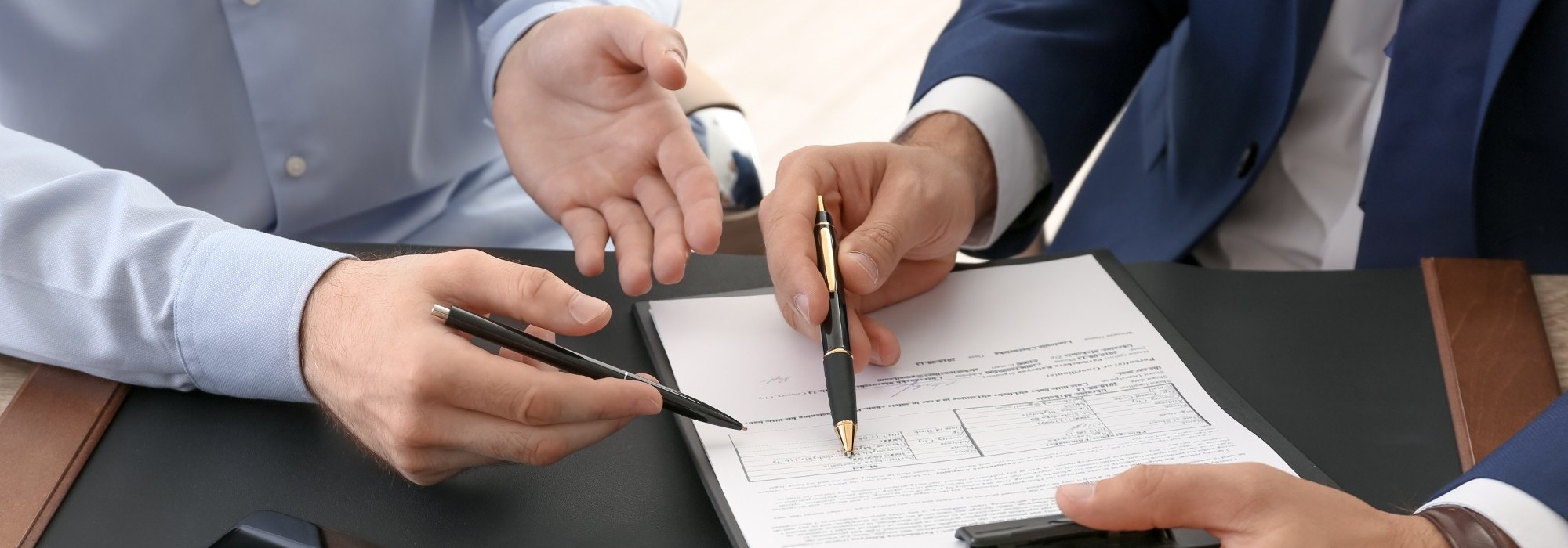two businessmen gesturing to paper